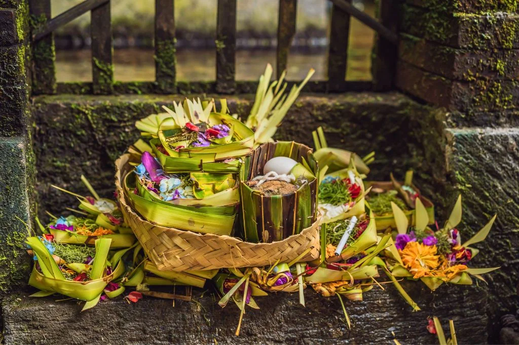 A Canang Sari offering placed at the entrance of a traditional Balinese compound.