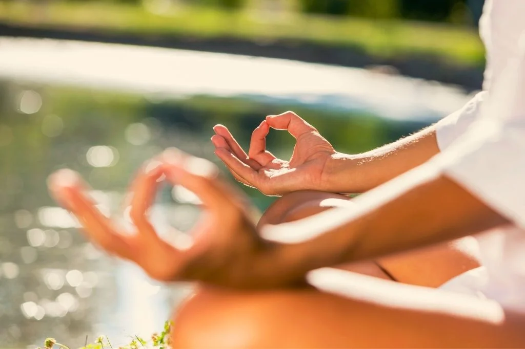 A close-up of hands resting in a meditative pose, representing focus during a beginner's meditation.