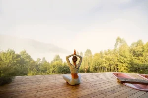 A person practicing a calm 5-minute morning meditation on a balcony overlooking a serene Bali view.
