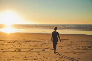 Walking in the sand on a serene Bali beach at sunrise, representing a mindful beach walk