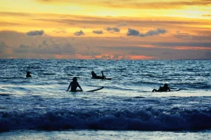 Beginner surfers learning on the gentle waves of a Bali beach, a perfect spot to practice surfing etiquette.